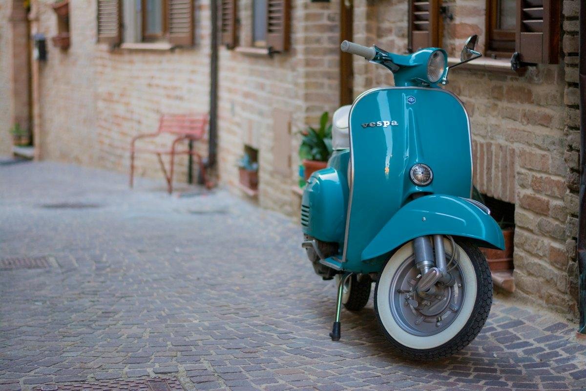 A turquoise Vespa on a cobbled street