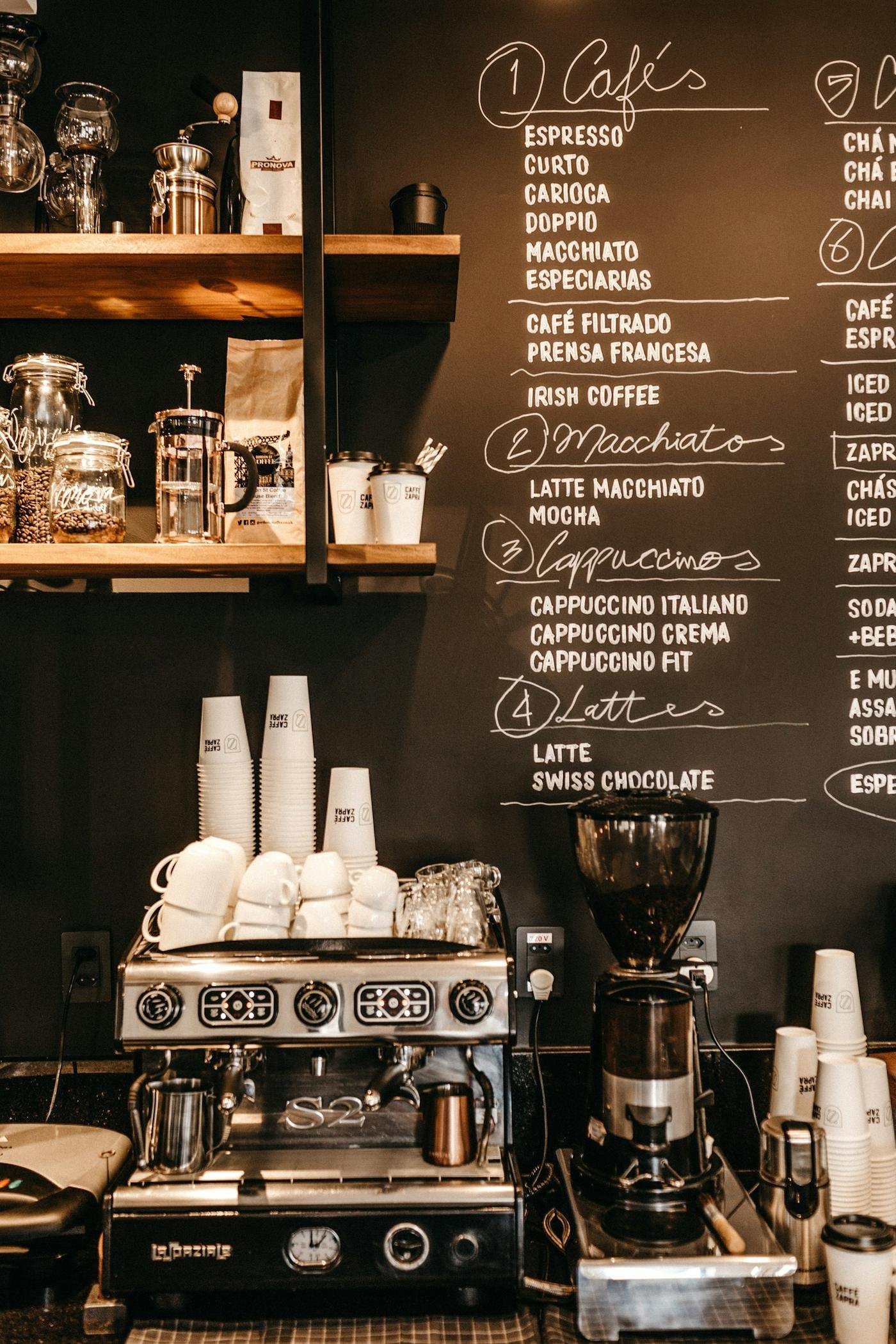 An espresso machine under a chalkboard menu in a café