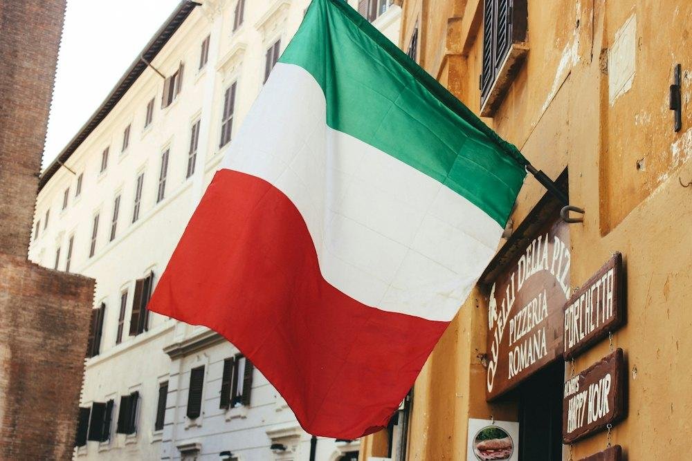 An Italian flag hanging over a street in Italy