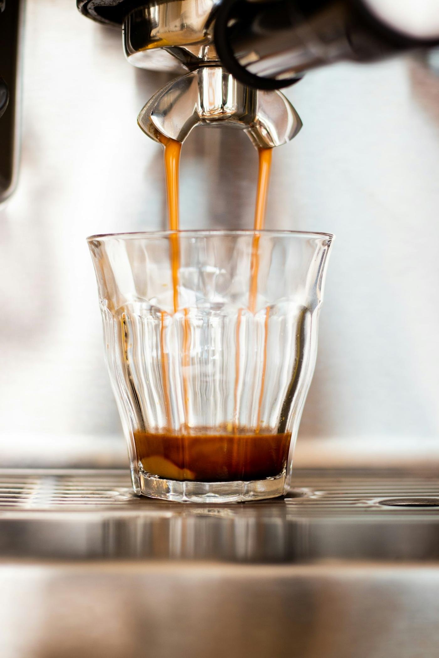 Espresso pouring into a glass at an Italian bar