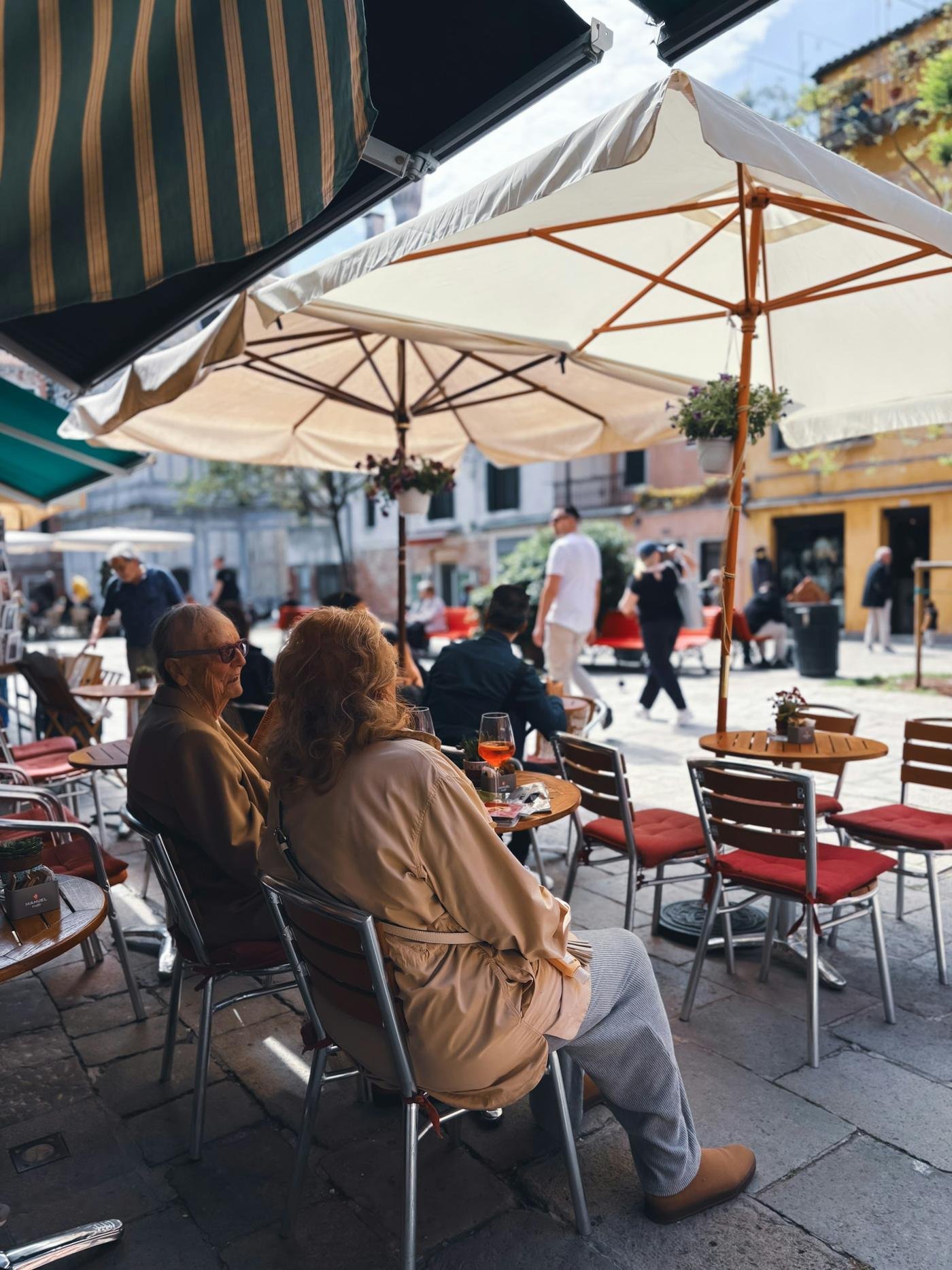 Friends talking at café tables in an Italian piazza