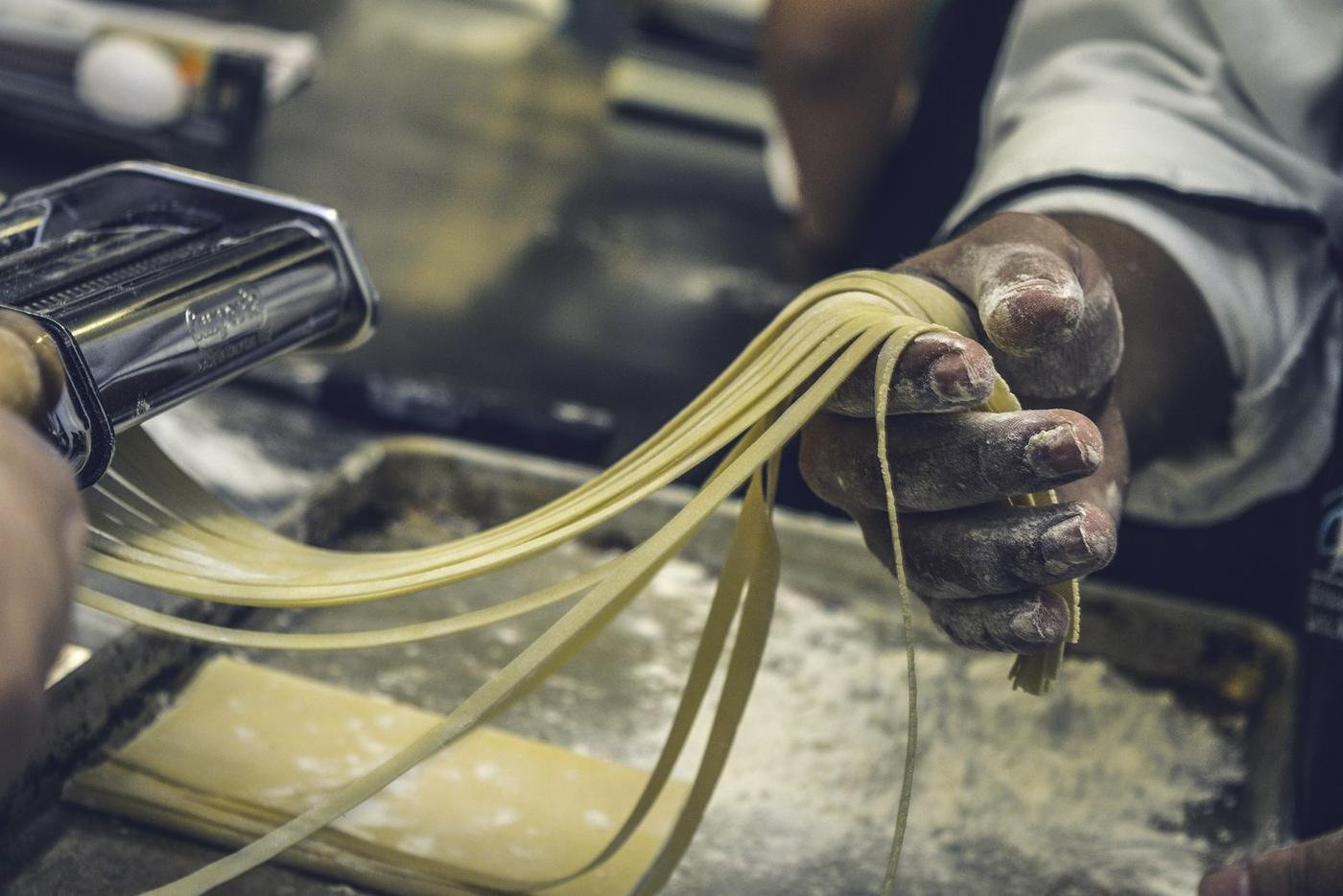 Hands making fresh pasta