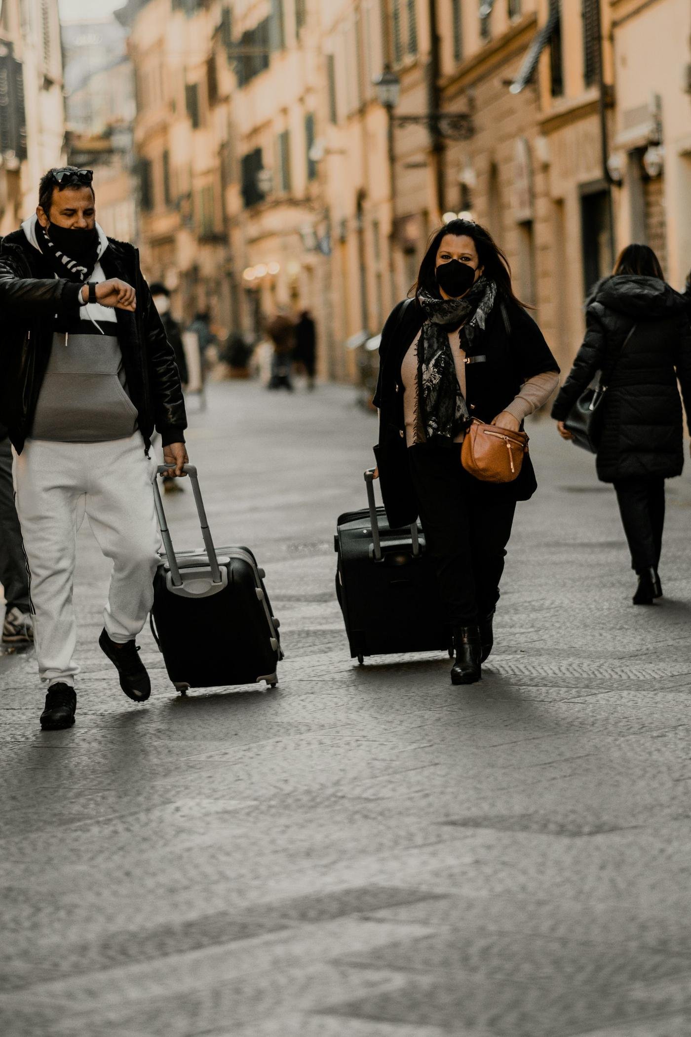 Travelers pulling suitcases along a stone street